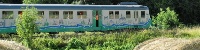 Train touristique avec en premier plan des bottes de paille à la campagne à Thoré-la-Rochette