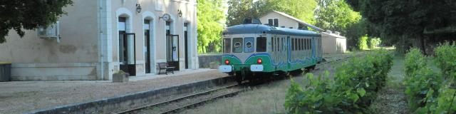 Train touristique derrière une gare