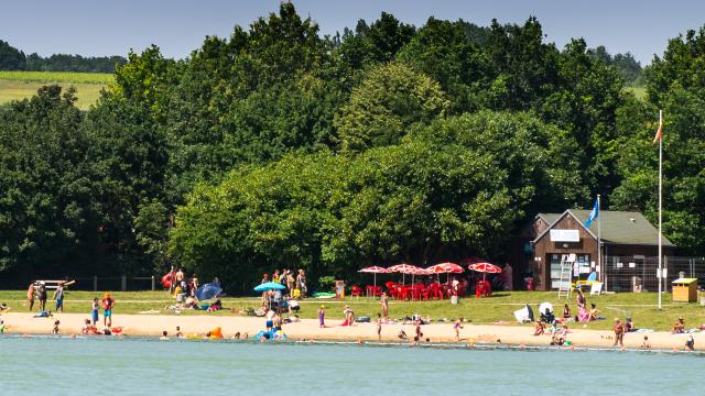 Plage de sable avec baigneurs au bord d'un plan d'eau