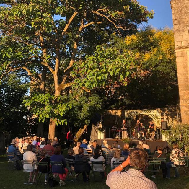 Public debout et assis devant une scène lors d'un concert