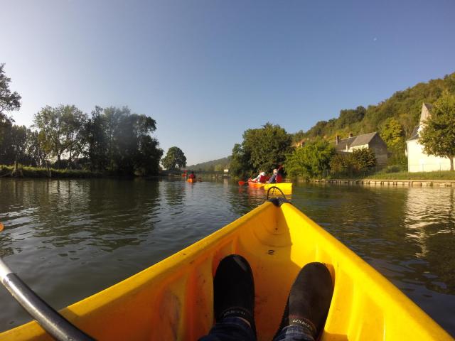 Posé dans un canoë sur une rivière avec vue sur d'autres canoës