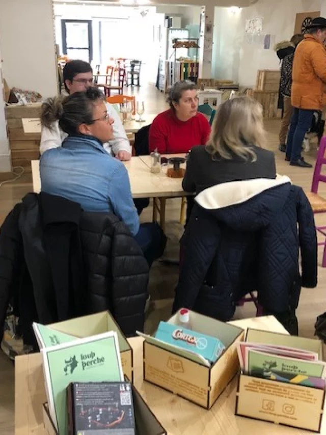 Personnes assises à table dans un bar avec au premier plan des jeux