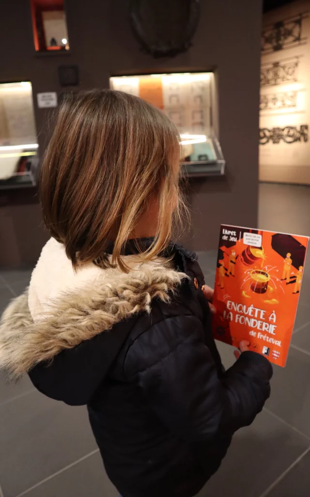 Jeune fille de dos regarde une affiche orangée