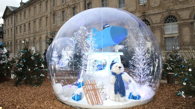 Boule de Noël avec nounours à l'intérieur devant un bâtiment historique