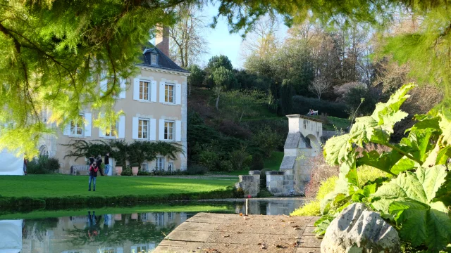 Jardin avec vue sur maison de caractère et point d'eau