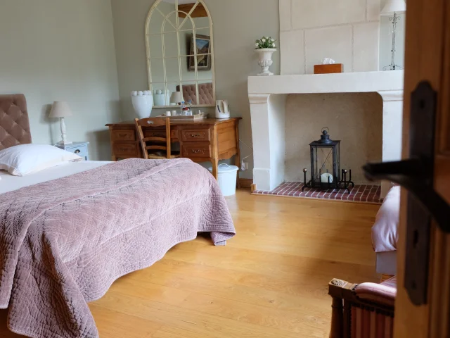 Entrée d'une chambre avec lit, cheminée, bureau