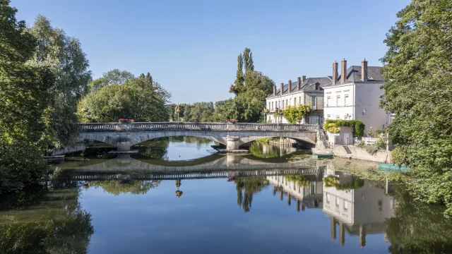 Vue sur la rivière le Loir avec un pont en arrière plan et maison de caractère à droite